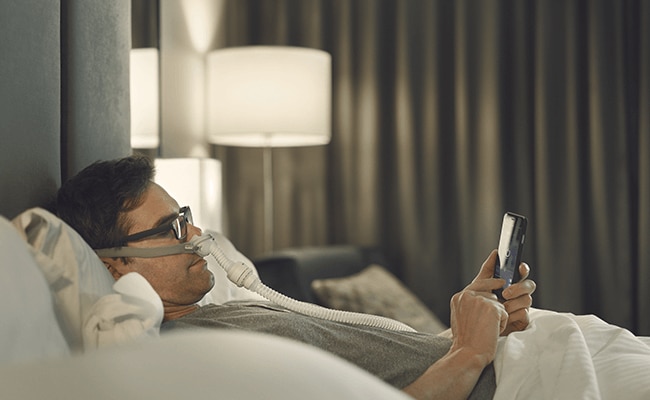 un monsieur dort avec son airmini à l'hôtel