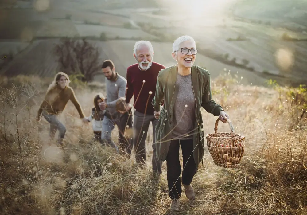 Une famille se promenant dans une prairie ensoleillée en souriant