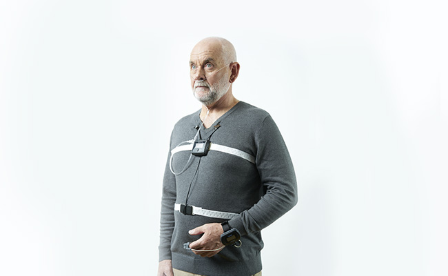 Homme debout avec un appareil de diagnostic d'apnée du sommeil