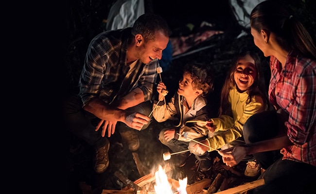 gens heureux en train de griller des marshmallows