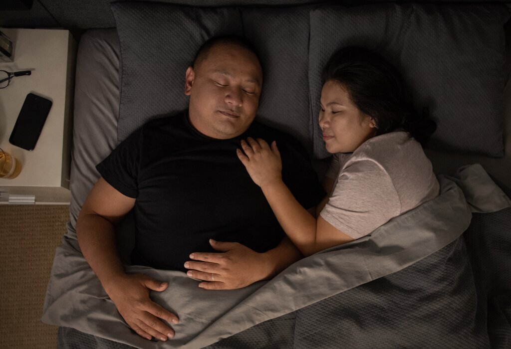 Couple dormant paisiblement, utilisant des conseils pour passer une bonne nuit de sommeil.
