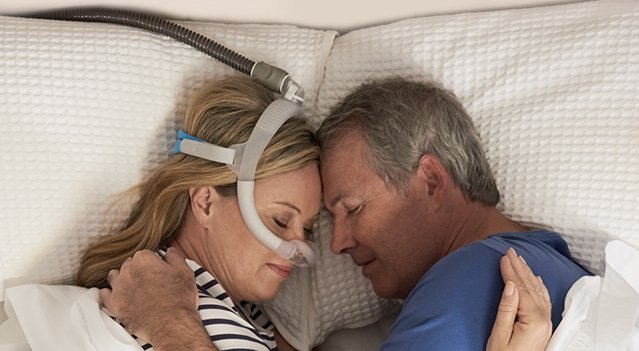 Couple enlacé en plein sommeil, femme utilisant le masque AirFit N30i-mobile
