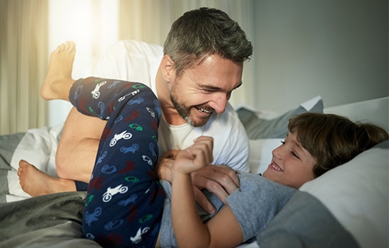 un papa reposé joue avec son fils