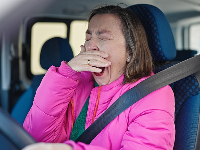  femme-d-age-mur-au-volant-qui-baille