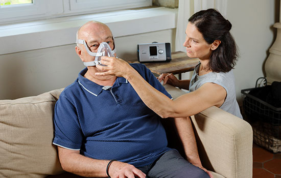 Médecin traitant son patient à domicile avec une ventilation non invasive