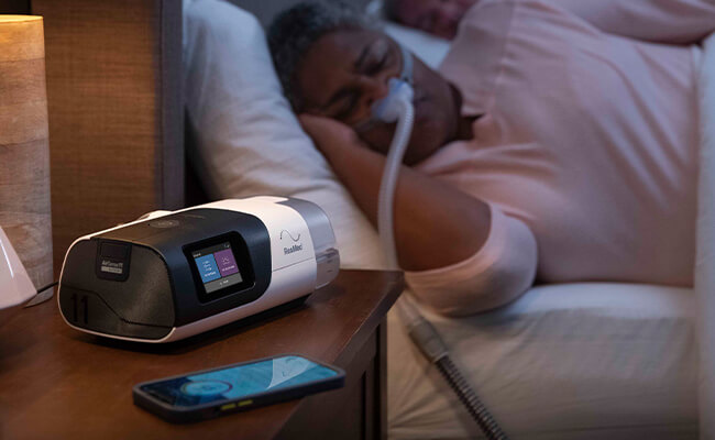 Patiente qui dort avec son AirSense11 d'apnée du sommeil ResMed