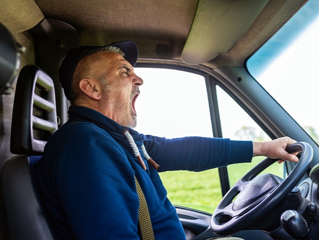  un-chauffeur-routier-epuise-baille-dans-sa-camionnette